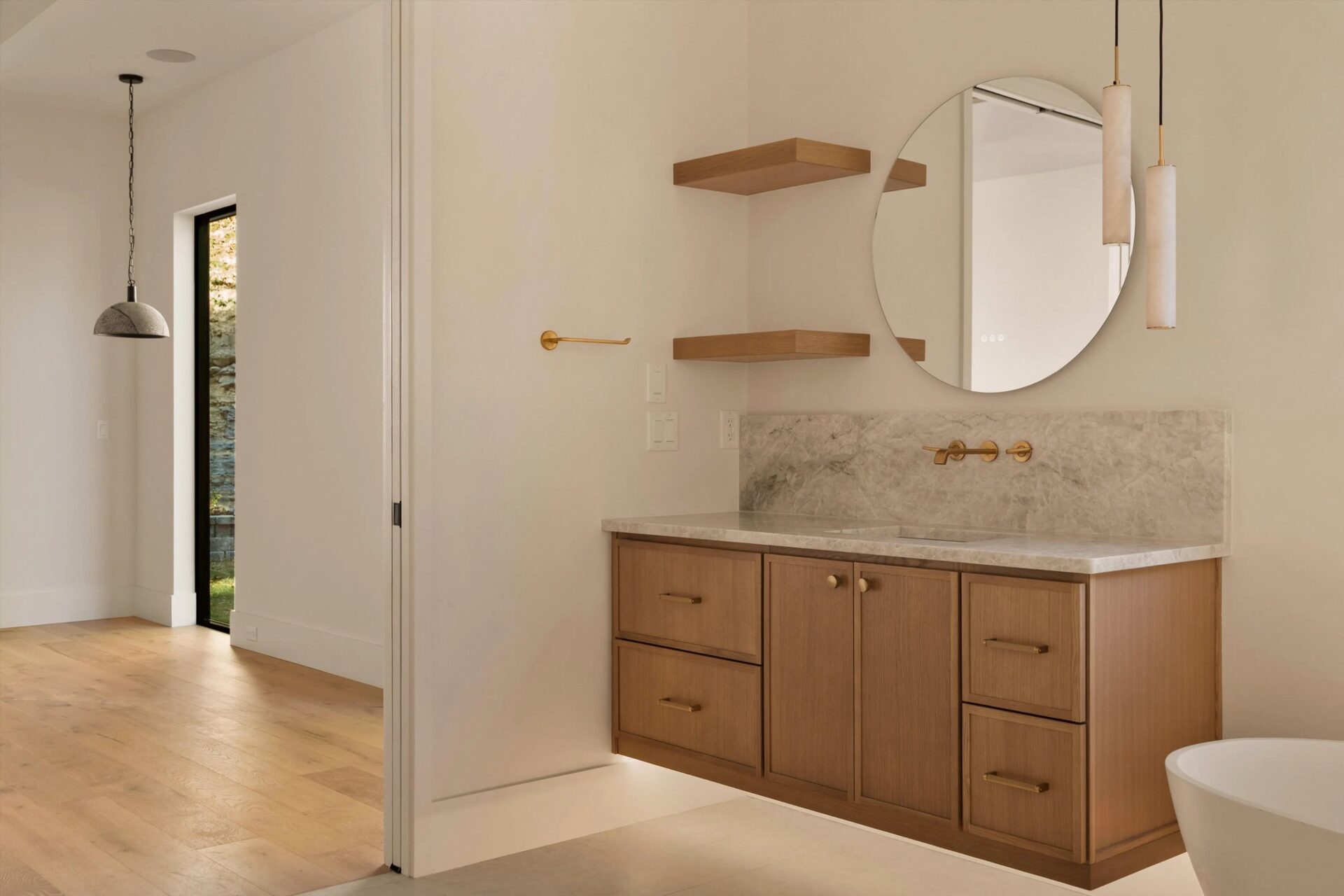 Bathroom vanity with a floating wood cabinet and round mirror