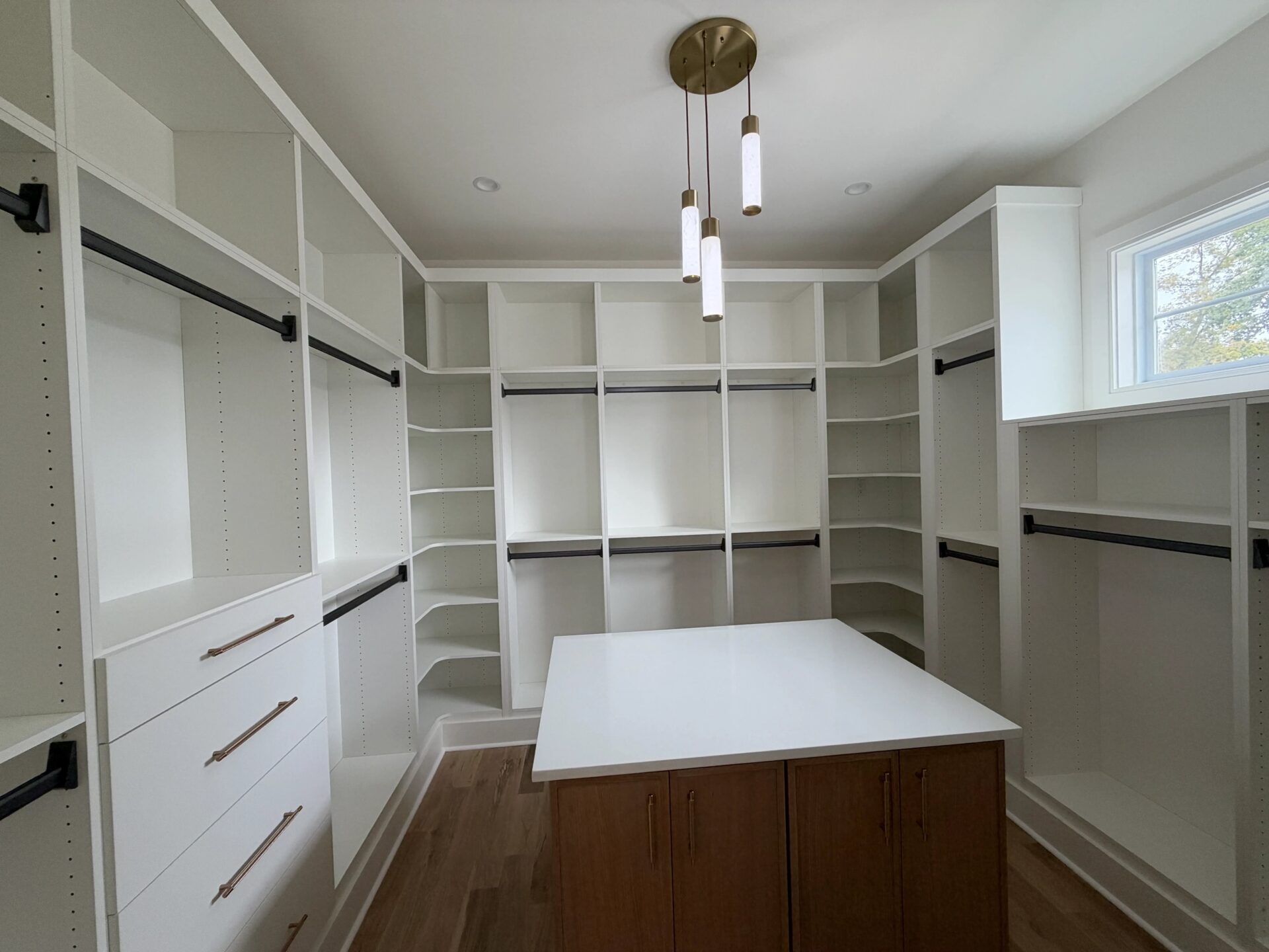 Walk-in closet with white shelving and a center island