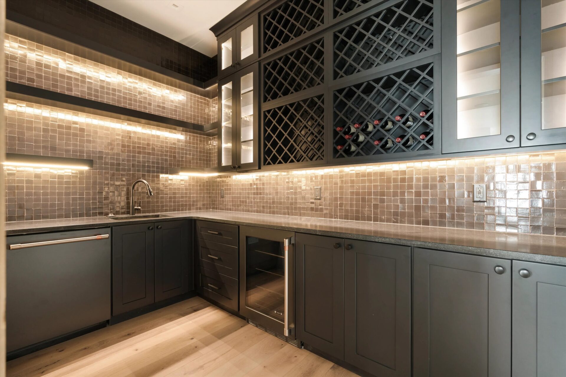 Dark cabinetry with a wine rack and under-cabinet lighting